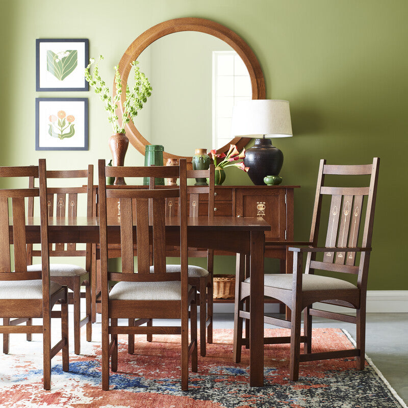 Dining room with a wooden table and chairs against a green wall. Harvey Ellis Collection. 