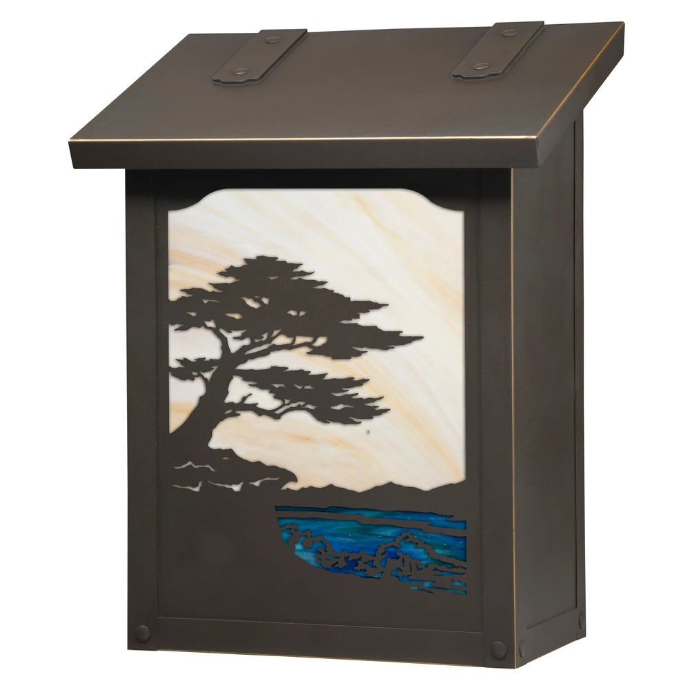 A rectangular outdoor light box with a dark bronze finish, featuring a decorative front panel with a black metal silhouette of a pine tree and blue water, set against a cream and gold sky.
