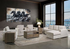 A staged modern living room featuring a light beige sectional sofa with a chaise, matching armchairs, a wooden coffee table, and a large multi-panel canvas wall art print depicting four black horses against a smoky background.