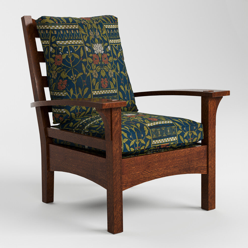 A wooden armchair with a dark brown frame and thick cushions featuring a navy blue, olive green, and red botanical pattern, shown against a light gray background.