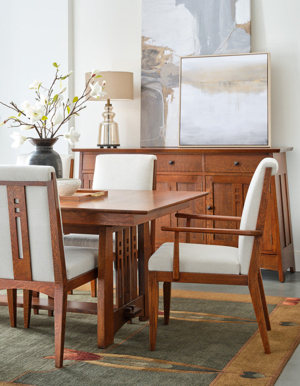 Dining room with wooden table and chairs, lamp, and abstract art on the wall.