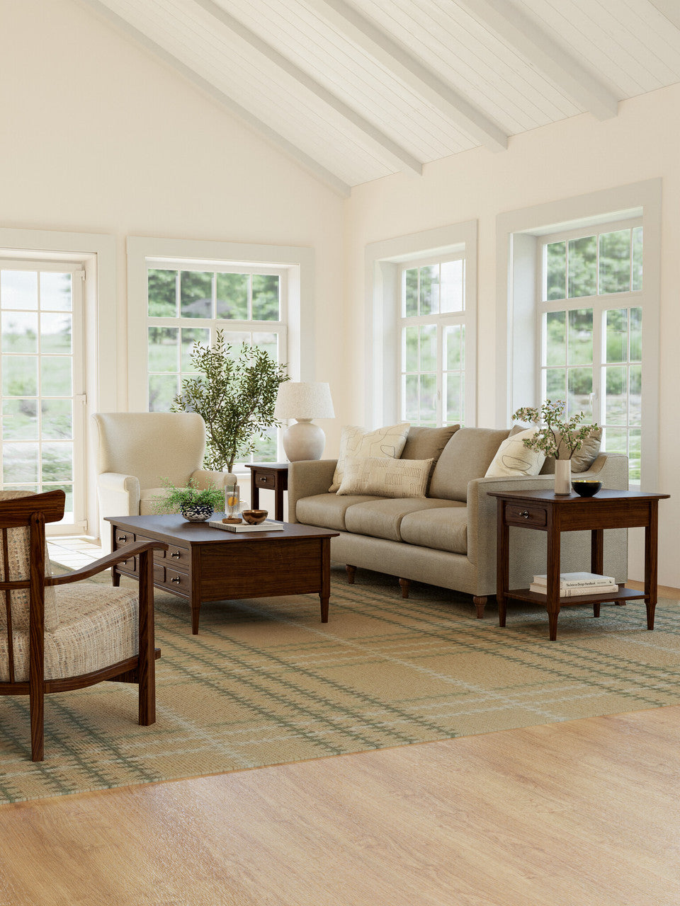 Living room with beige sofa, wooden coffee table, and armchair in a bright room with large windows.