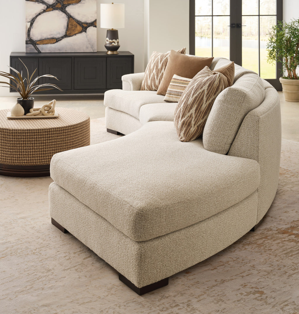 Beige sectional sofa in a living room setting with decor elements.