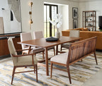 Dining room with wooden table and chairs, rug, and wall art.