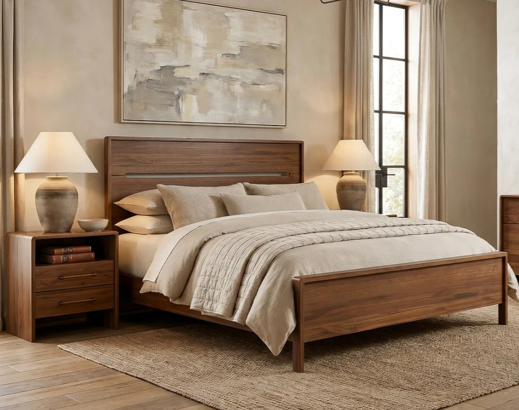 A medium brown wooden bed frame with a matching headboard and footboard, styled in a warm, neutral-toned bedroom with beige bedding, two matching nightstands, table lamps, and a textured rug.
