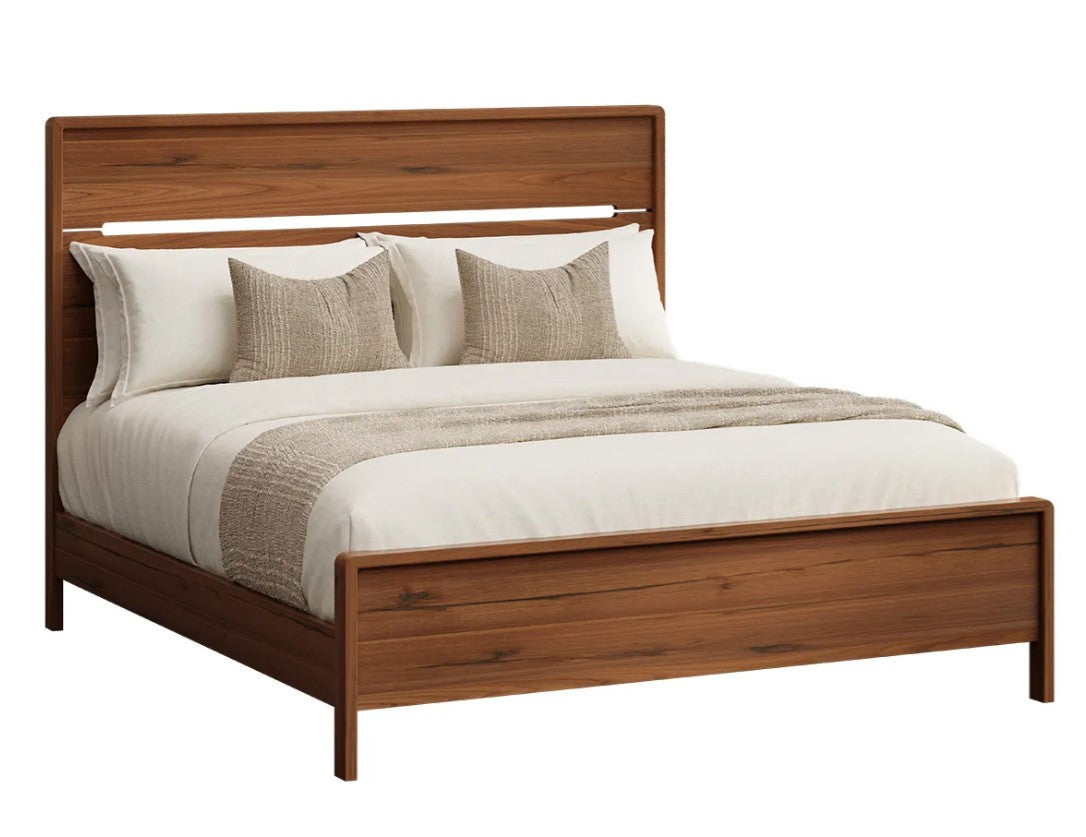 A modern wooden bed frame with a tall headboard and footboard, styled with white bedding, two beige textured pillows, and a beige throw blanket, shown against a plain white background.