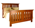 A wooden bed frame with a slatted headboard and footboard, shown with beige bedding and pillows on a plain white background.