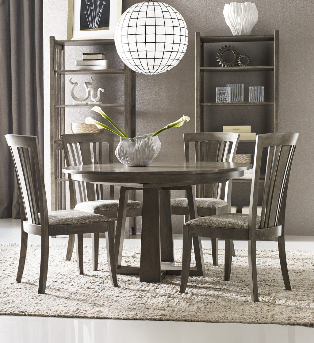 Dining room with wooden table and chairs, bookshelves, and decorative items.