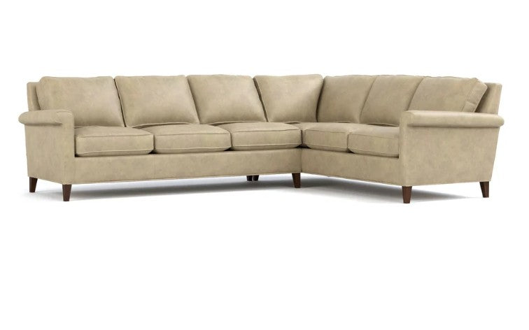 A light beige upholstered sectional sofa with a right-facing L-shape, featuring plush back cushions, thick seat cushions, rolled arms, and dark tapered wooden legs, shown against a plain white background.