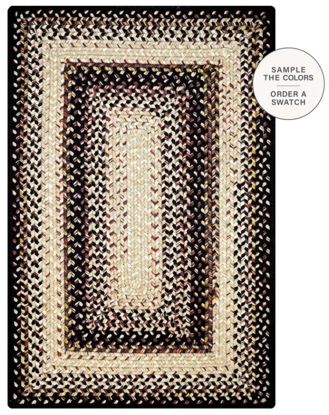 A rectangular braided area rug with concentric borders in black, beige, and cream tones, shown flat against a white background with a circular callout that reads 'SAMPLE THE COLORS ORDER A SWATCH'.
