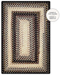 A rectangular braided area rug with concentric borders in black, beige, and cream tones, shown flat against a white background with a circular callout that reads 'SAMPLE THE COLORS ORDER A SWATCH'.