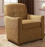Patterned armchair in a room with a window and side table.