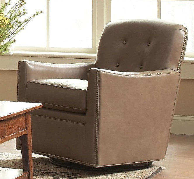 Brown leather armchair in a room with a wooden table and window.
