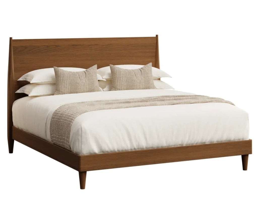 A modern wooden bed frame with a slanted headboard and footboard, styled with white bedding, textured beige pillows, and a beige throw blanket, shown against a plain white background.