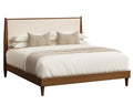 A modern medium brown wooden bed frame with a cream upholstered headboard, styled with white bedding, two textured beige pillows, and a beige throw blanket, shown against a solid white background.