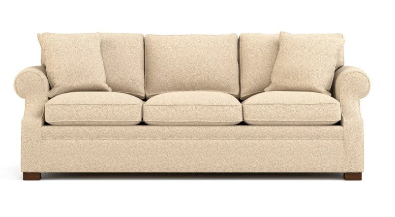 A three-seater loveseat sofa upholstered in a textured beige fabric, featuring rolled arms, four matching back cushions, and a low-profile rectangular base with dark wood feet, shown against a plain white background.