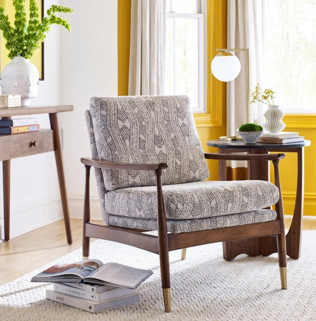 Patterned armchair in a living room with yellow walls and decor.