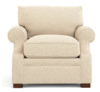 A classic upholstered armchair in a textured beige fabric, featuring rolled arms, a thick seat cushion, and dark brown wooden legs, shown against a plain white background.