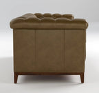 A brown leather Chesterfield sofa shown from the rear three-quarter view, featuring deep button tufting on the backrest and a dark wood base with tapered legs, set against a neutral light gray studio background.