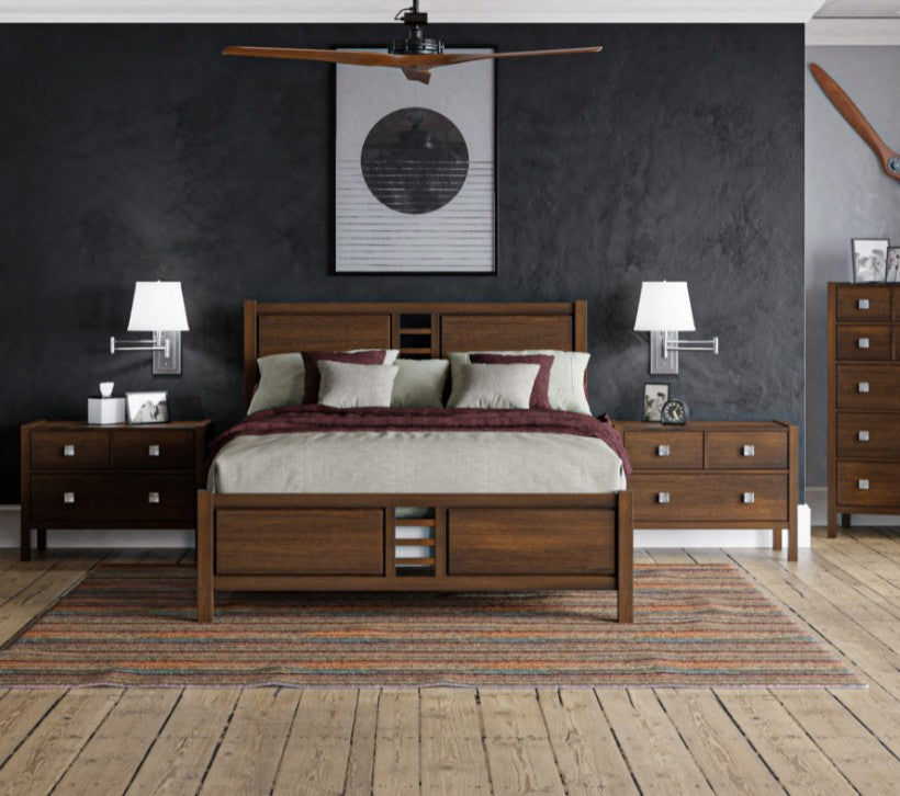 A medium brown wooden bed frame with a matching headboard and footboard, styled in a modern bedroom with dark gray walls, wooden floors, and matching nightstands.