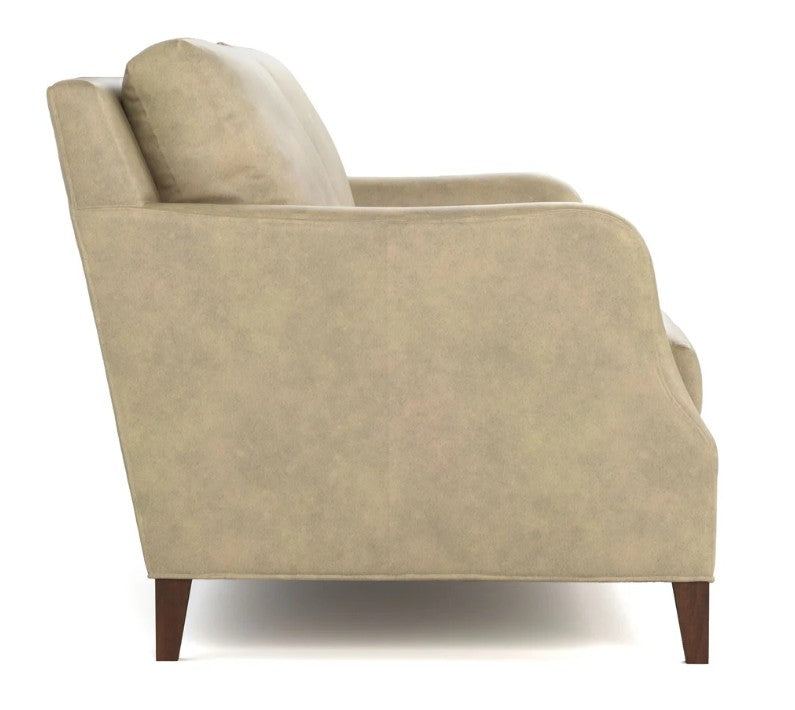 A side-view shot of a beige upholstered armchair with dark brown wooden legs, set against a plain white background.