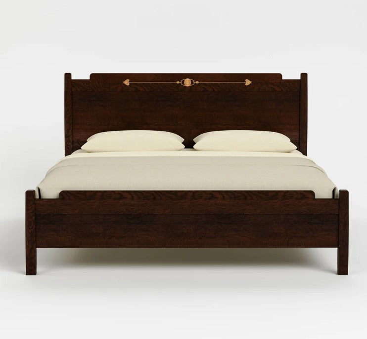 A dark brown wooden bed frame with a high headboard and footboard, styled with cream-colored bedding and two pillows against a light gray background.
