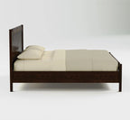 A modern dark brown wooden bed frame with a low headboard and footboard, shown with cream-colored bedding and two pillows against a light gray background.