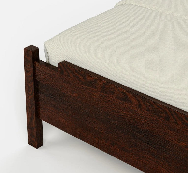 Close-up of a dark brown wooden bed frame corner with a light beige textured mattress or bedding on a clean white background.