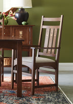 Wooden dining table and chairs against a green wall
