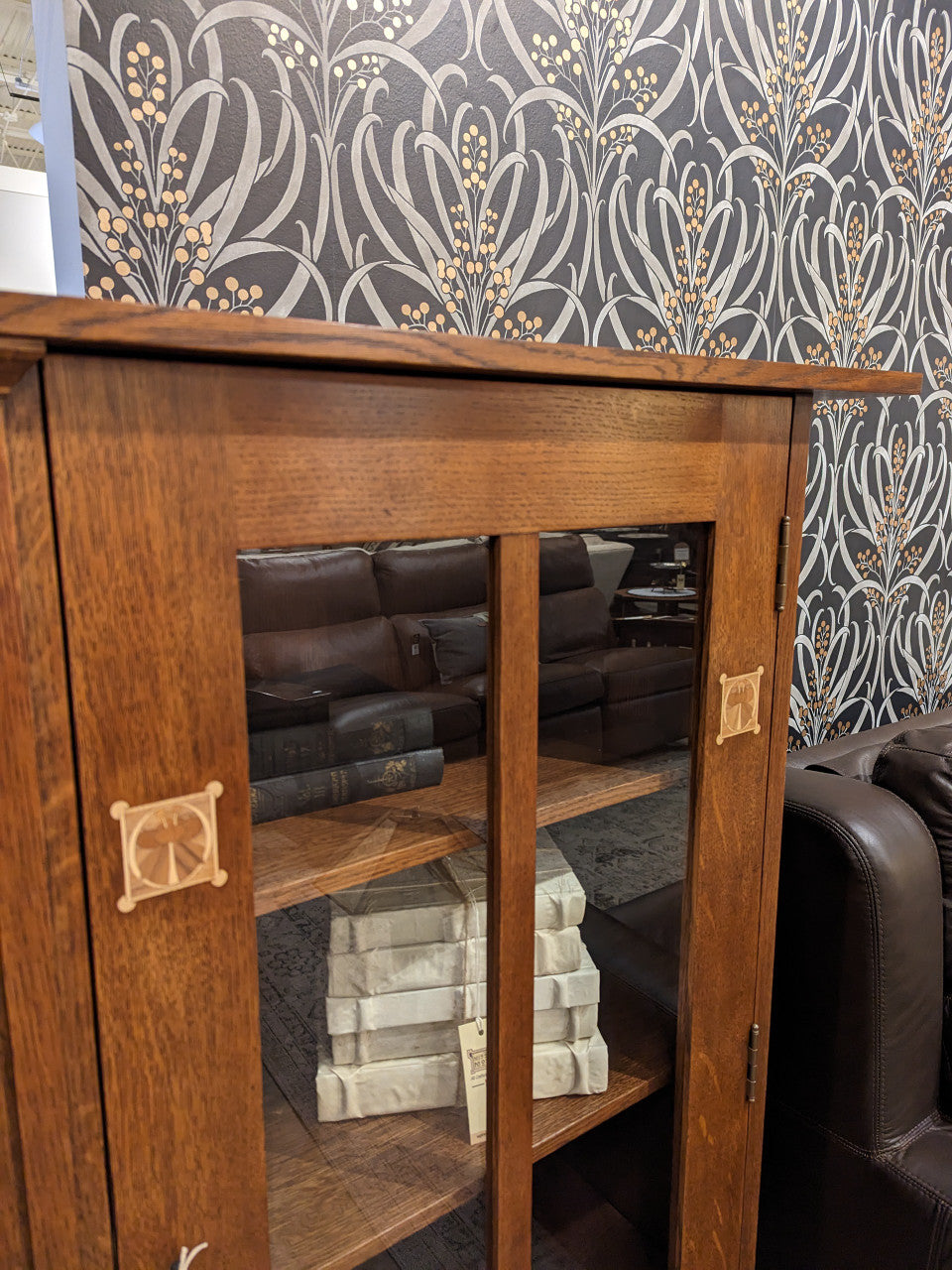 Harvey Ellis Wooden bookshelf with glass doors displaying books and decorative items on a white background