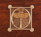 Wooden inlay design on a wooden surface.
