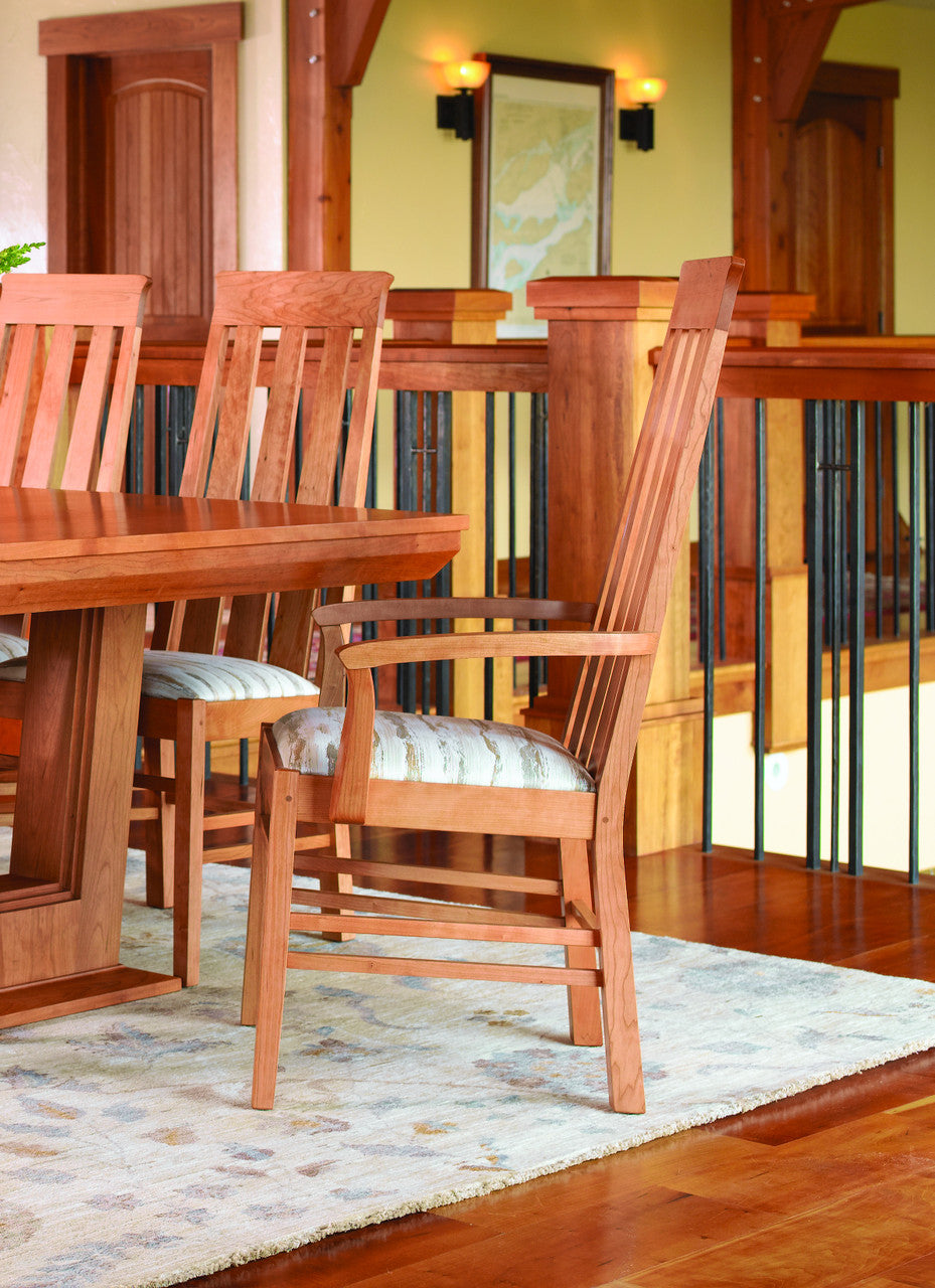 Wooden dining table and chairs with a staircase in the background