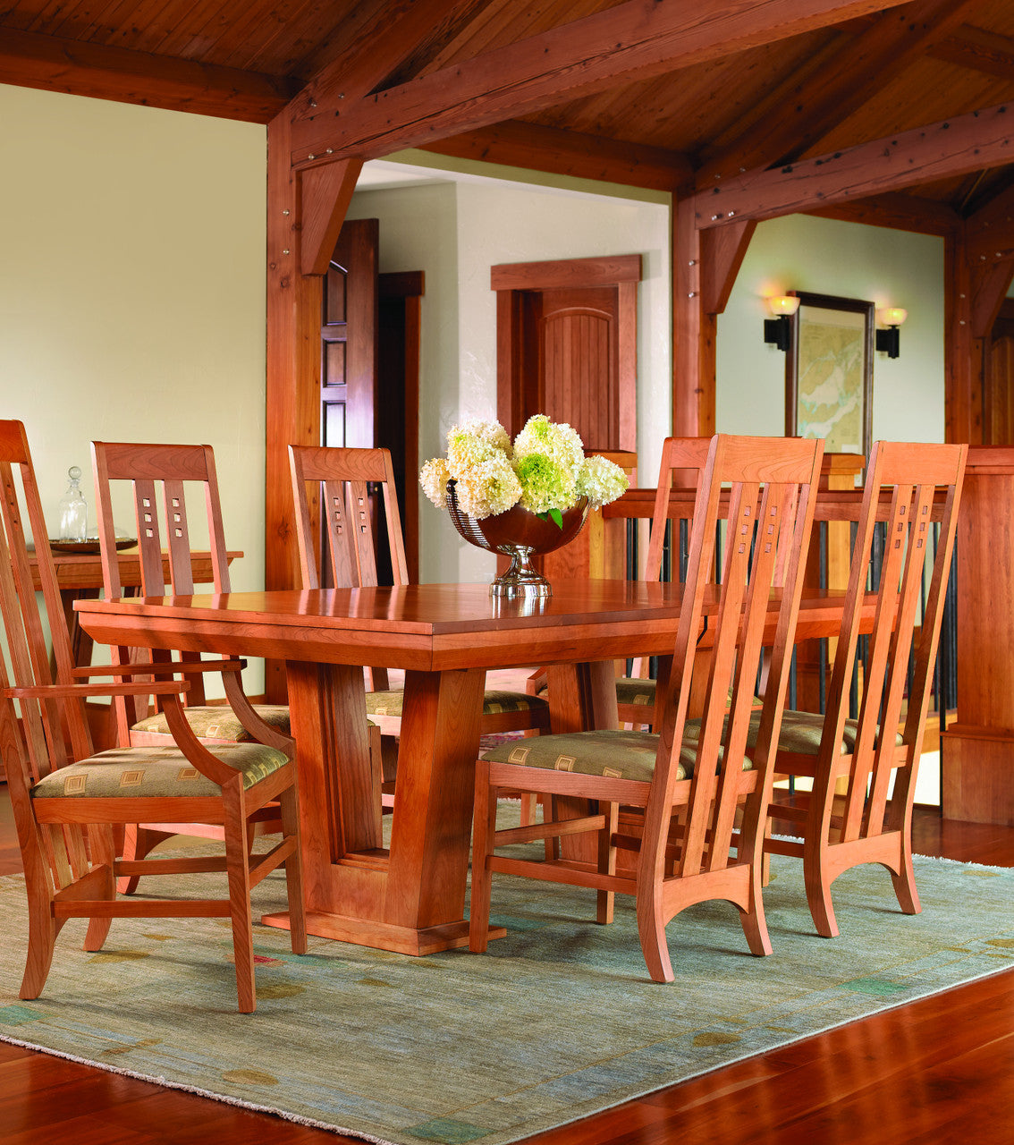 Wooden dining table with chairs in a room with wooden beams and a mirror.