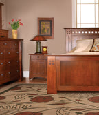 Wooden bedroom furniture set with a lamp, clock, and decorative items on a patterned rug.