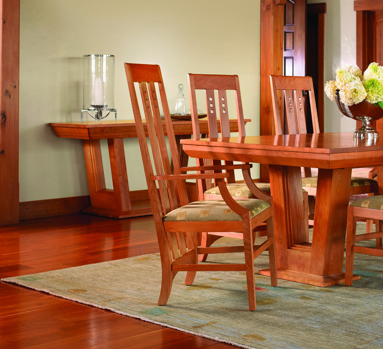 Wooden dining table and chairs in a room with a lamp and decorative items.