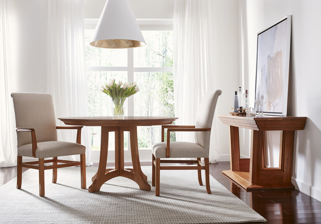 Dining room with wooden table and chairs, white walls, and a television on a stand.