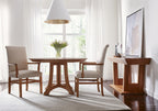 Dining room with wooden table and chairs, white walls, and a television on a stand.