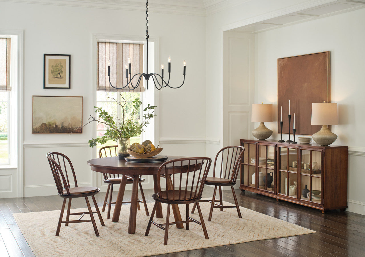 Dining room with wooden table and chairs, chandelier, and sideboard.