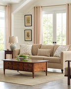 Living room with beige sofa, wooden coffee table, and framed pictures on the wall.