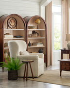 Cozy living room with a beige armchair, bookshelves, and decorative items.