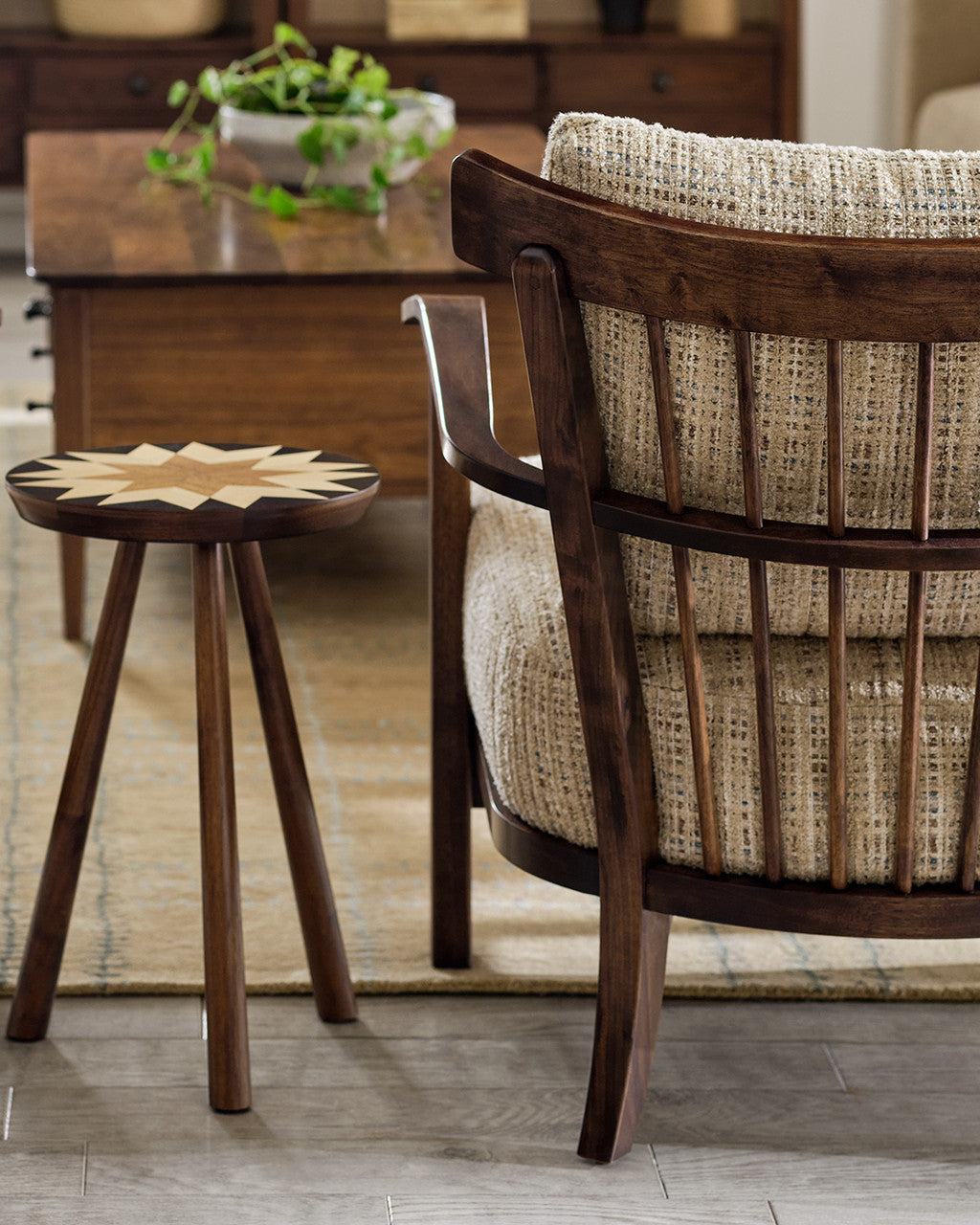 Wooden chair with woven backrest and a small round table in a room setting.