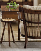 Wooden chair with woven backrest and a small round table in a room setting.