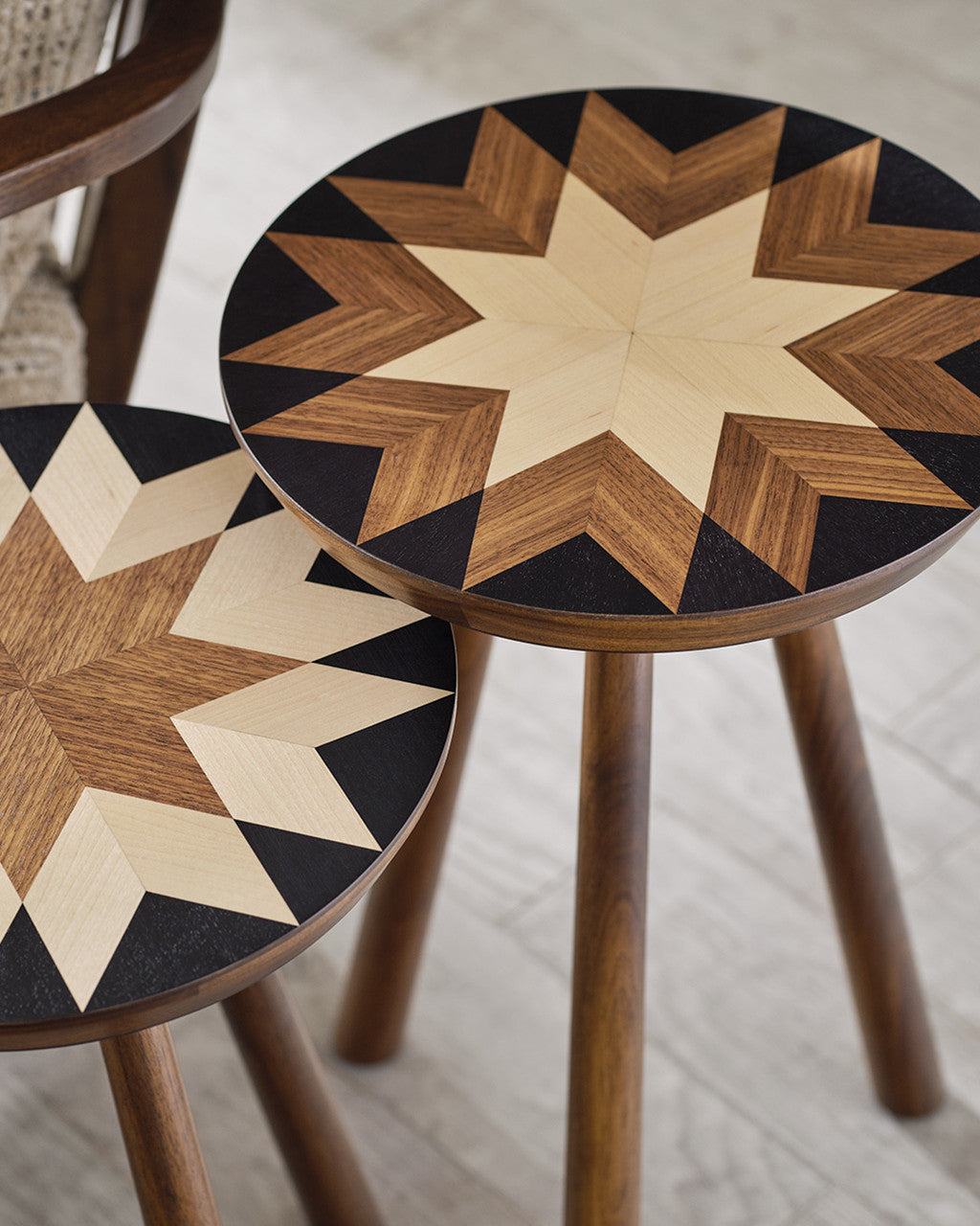 Two wooden side tables with star-shaped inlay design on a light wood floor.