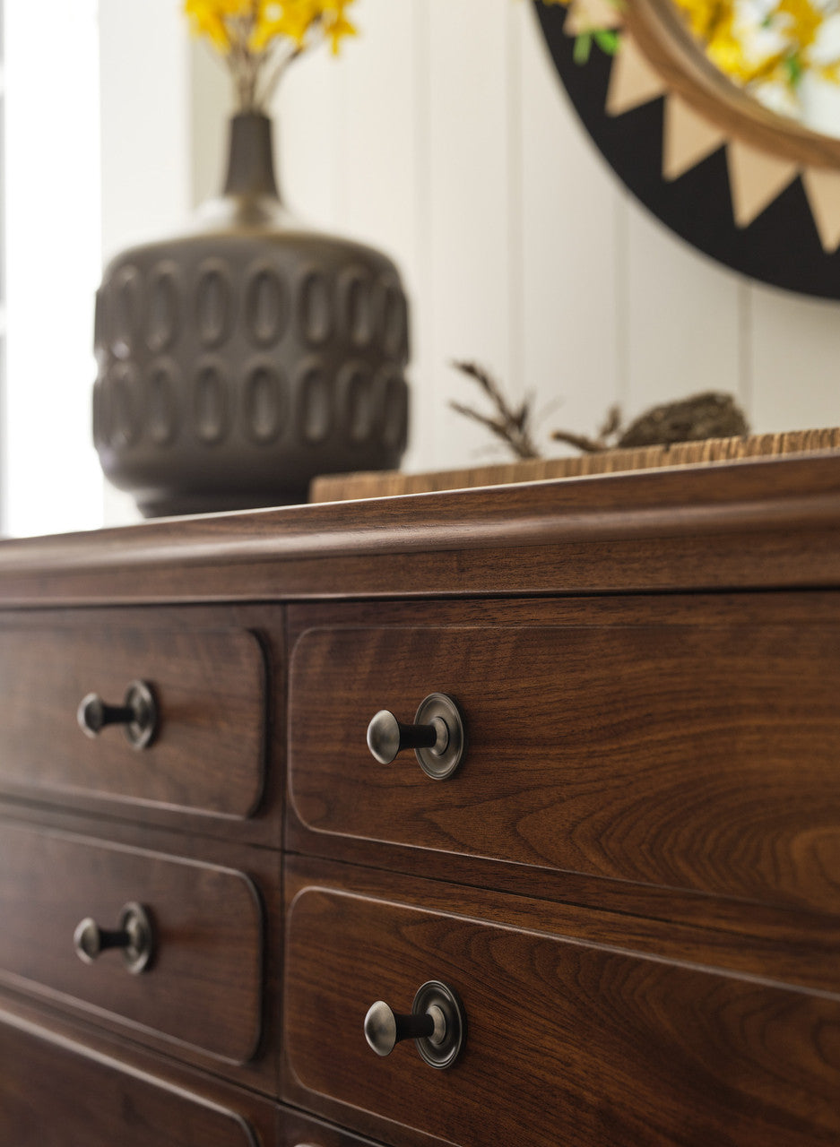 Wooden dresser with metal handles in a room setting