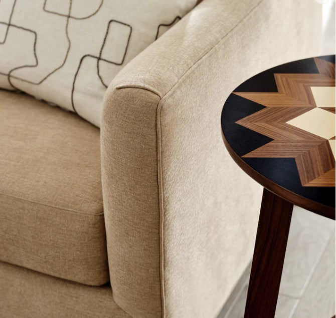 Beige sofa with a decorative side table featuring a geometric pattern.