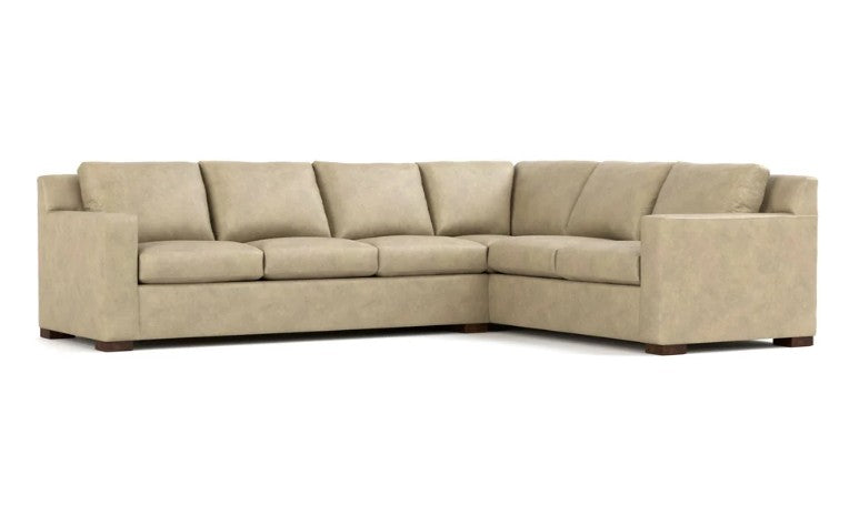 A light beige sectional sofa with a right-facing L-shape, featuring plush square back cushions, segmented seat cushions, and dark brown wooden feet, shown against a plain white background.