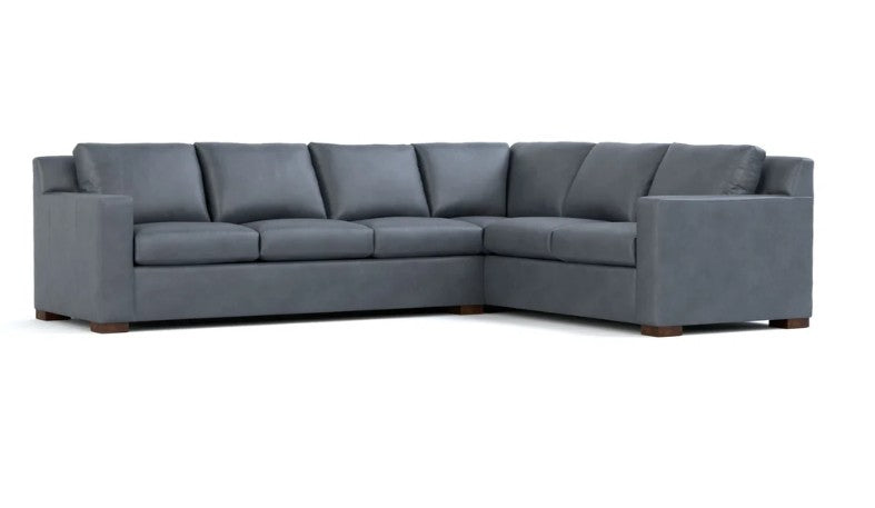 A modern L-shaped sectional sofa upholstered in dark gray fabric, shown from a three-quarter angle against a plain white background.
