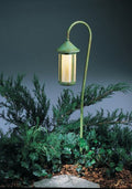 Decorative outdoor lamp with green metal fixture and glass shade, set against a dark background.