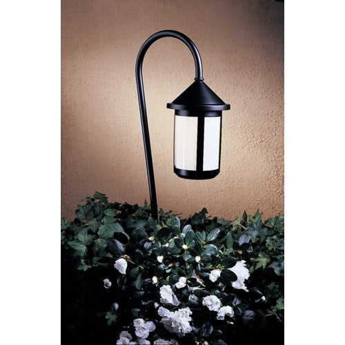 Black outdoor lamp post with white flowers and greenery on a beige wall background