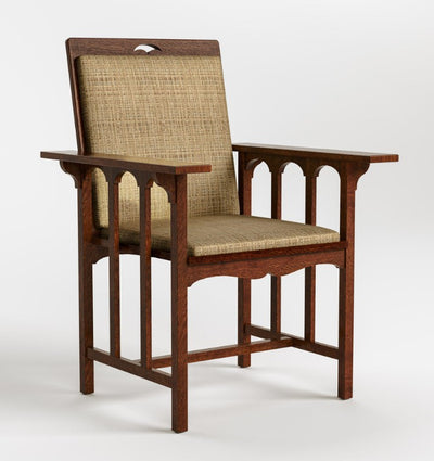 A classic armchair with a dark brown wooden frame, featuring woven cane backrest and seat cushions, shown against a plain light gray background.
